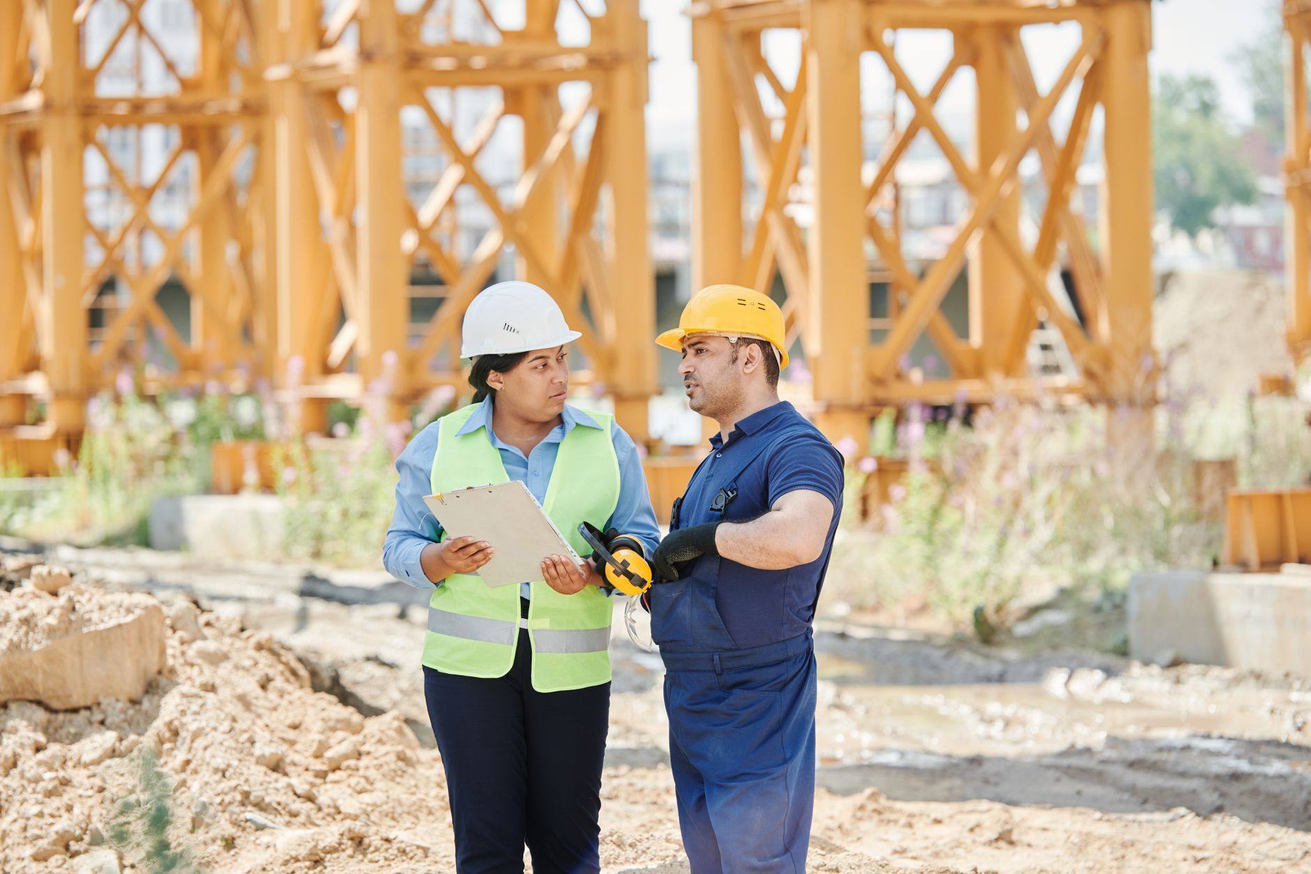 Engineers in hard hats reviewing drawings on site